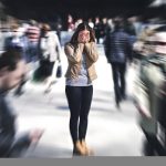 Pessoa enfrentando crise de pânico em local público movimentado com sensação de ansiedade