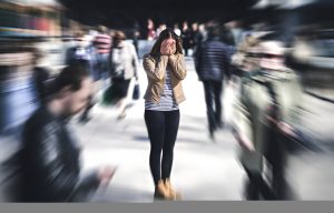 Pessoa enfrentando crise de pânico em local público movimentado com sensação de ansiedade